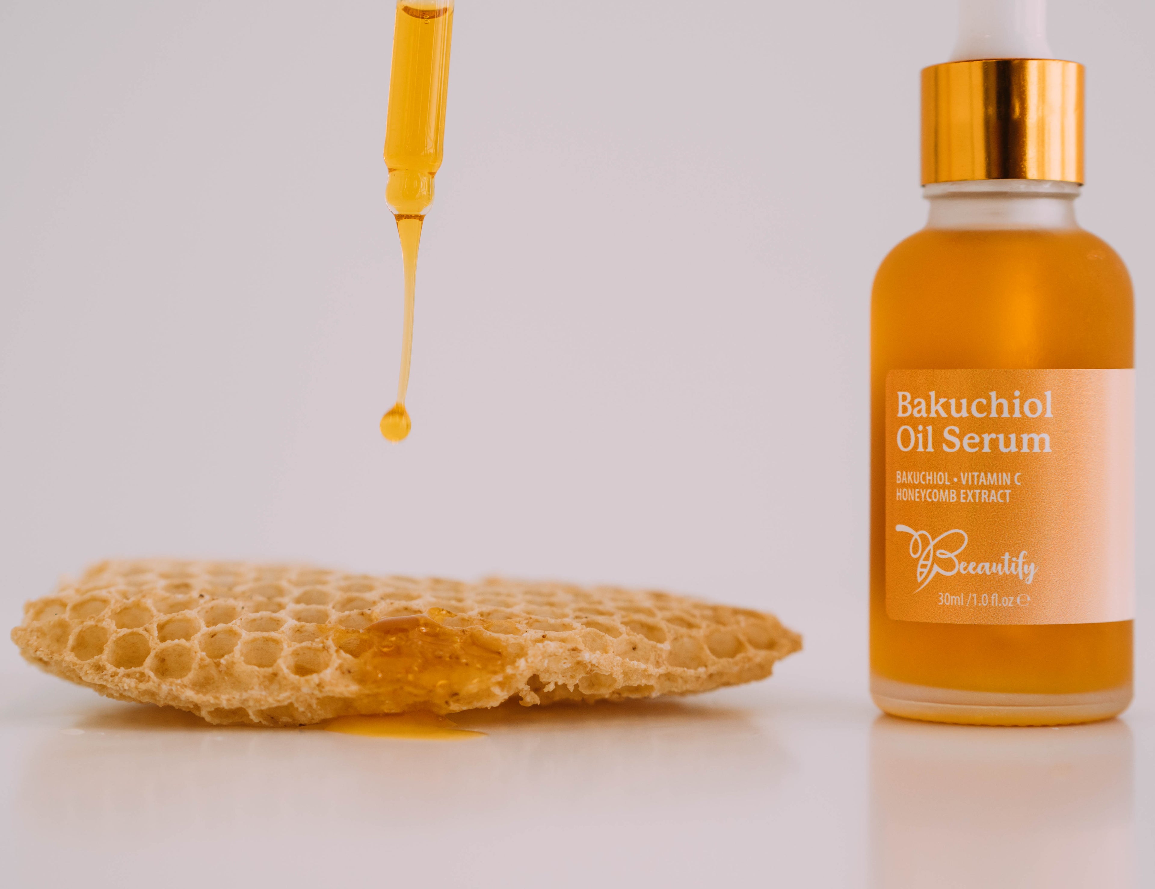 Bakuchiol oil serum bottle with dropper and sponge on a light background